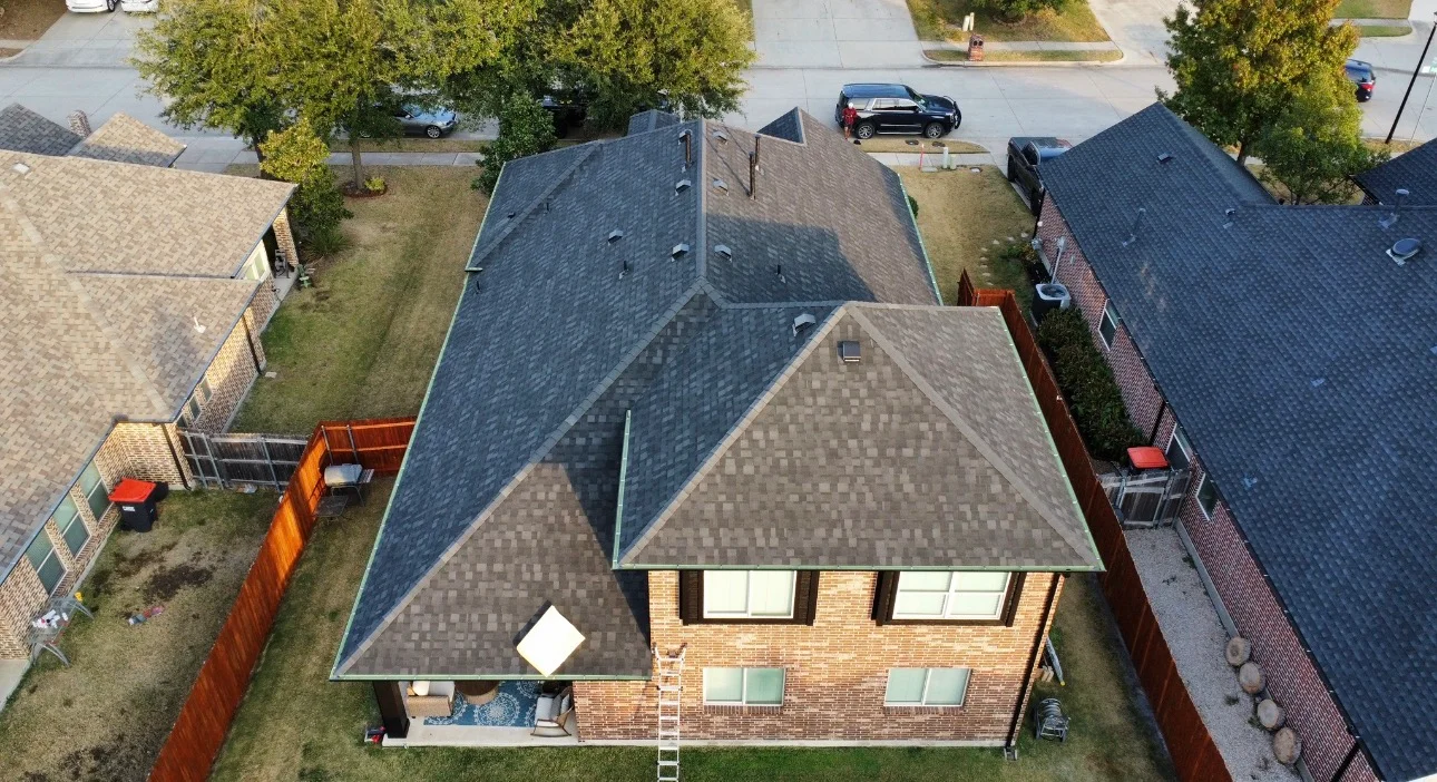 Aerial view of brick home with new charcoal gray dimensional shingle roof installation