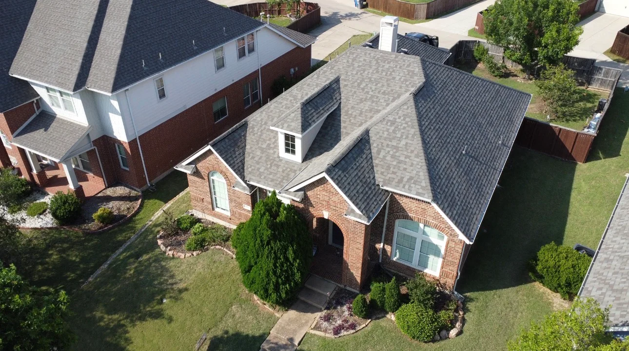 Aerial view of brick home with new gray architectural shingle roof installation