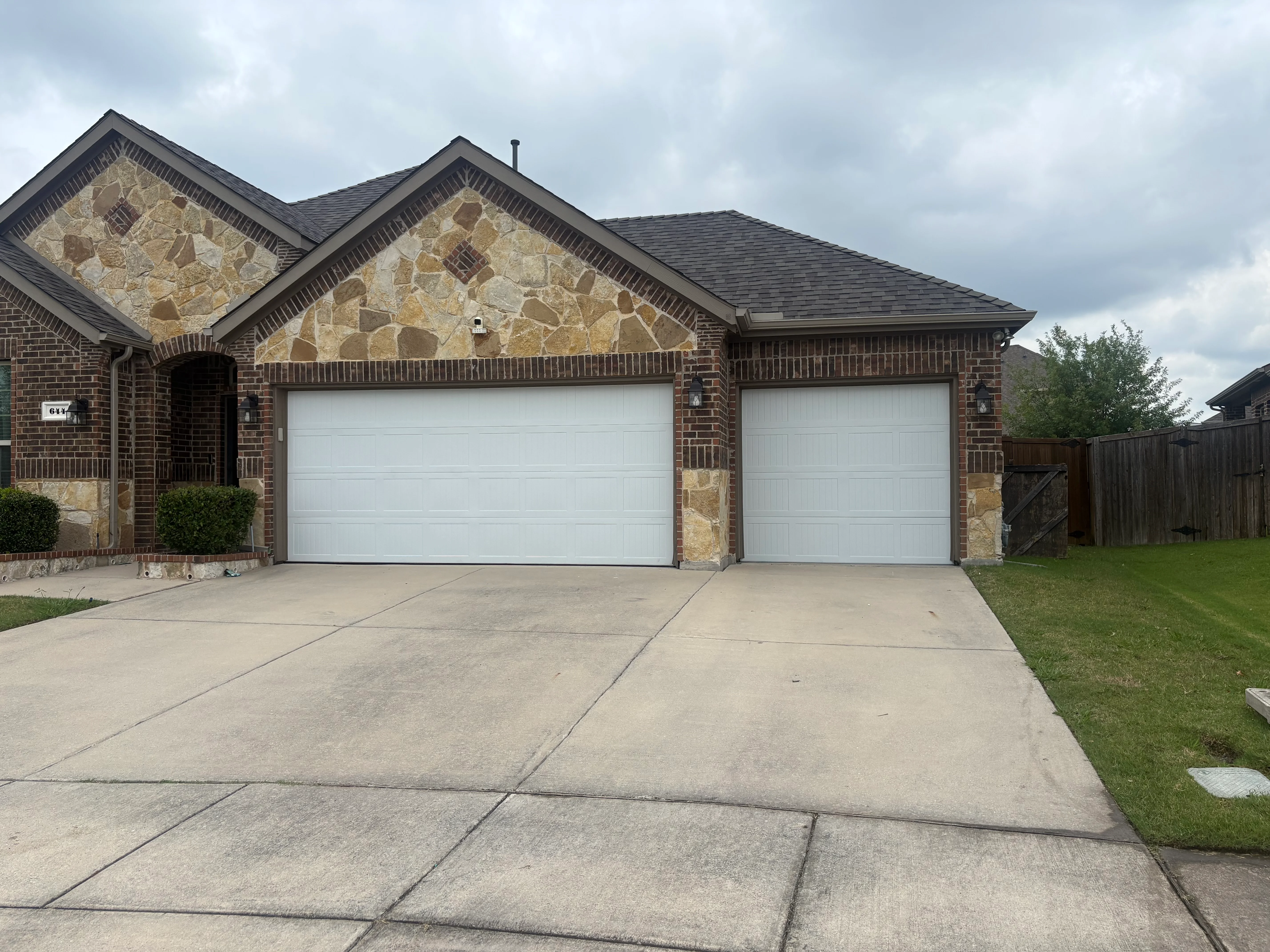 New architectural shingle roof on brick home with two-car garage in Princeton, TX