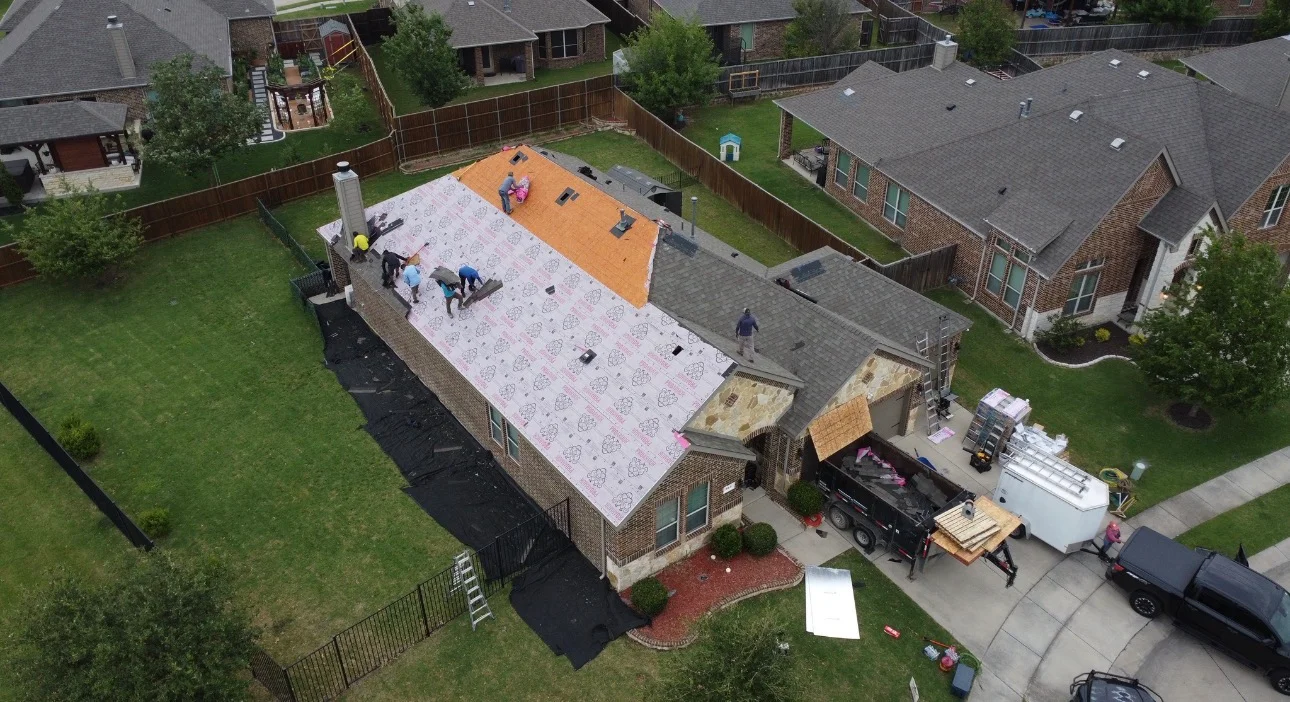 Aerial view of residential roof replacement with new shingles and installation crew at work