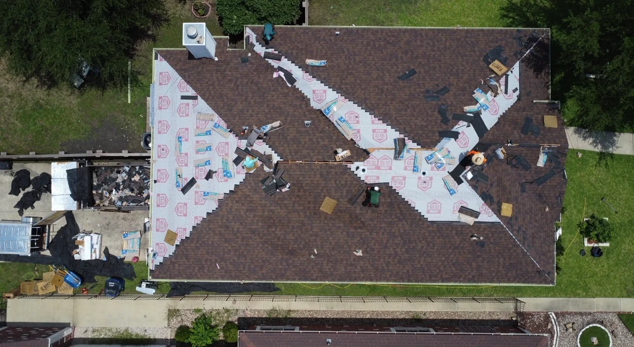 Aerial view of residential roof replacement with brown shingles and white underlayment